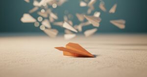 A single focused paper airplane aimed cleanly while many others scatter in the blur behind it